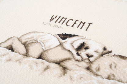 Cross stitched birth record with a baby and a dog