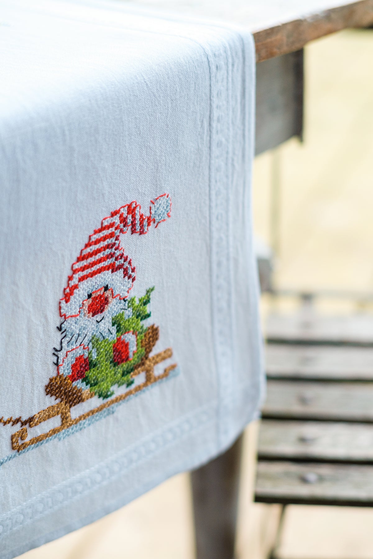 Embroidered table runner with gnome and reindeer motifs
