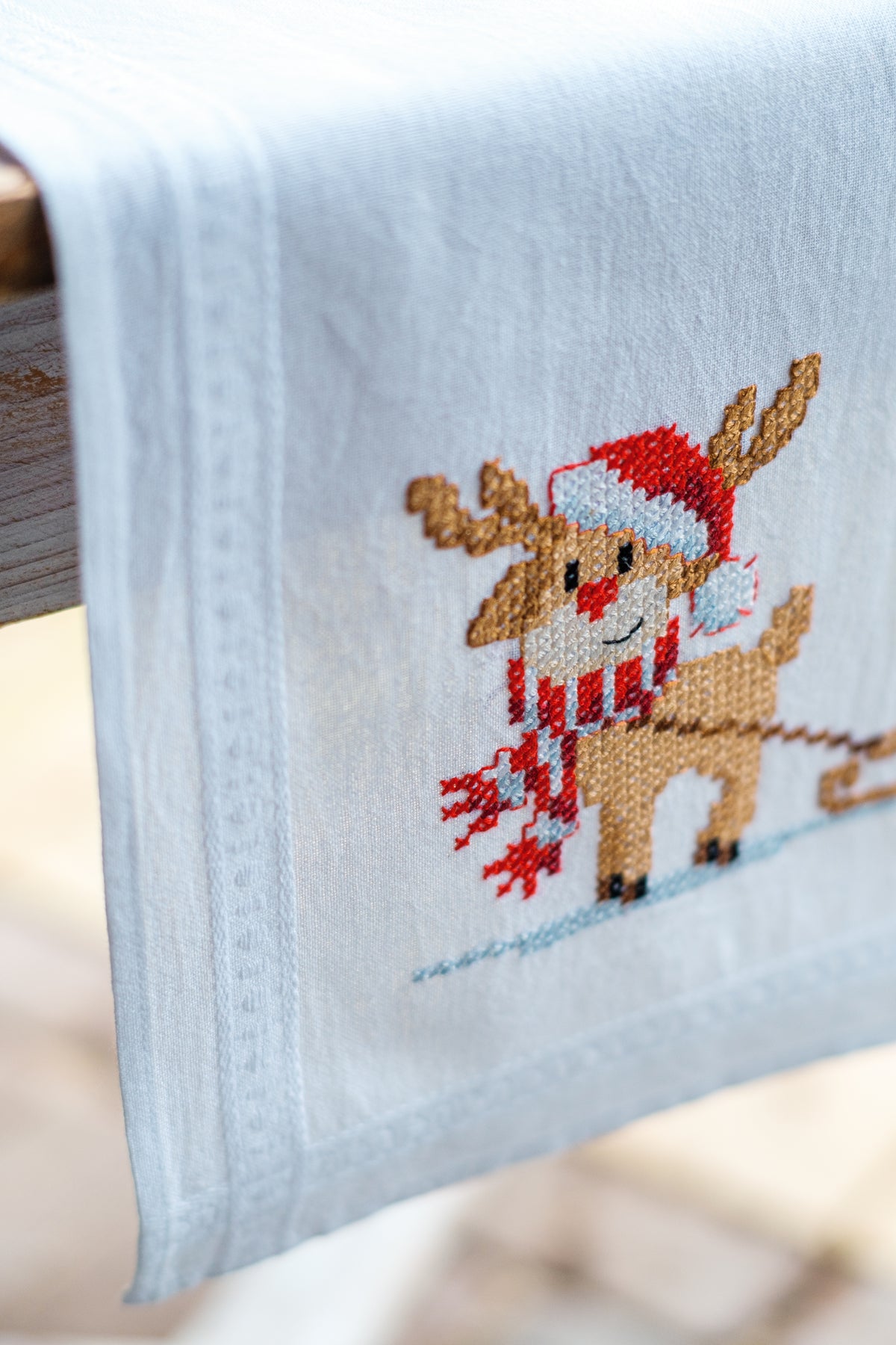 Embroidered table runner with gnome and reindeer motifs