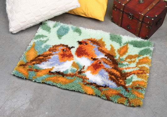 Latch hook rug showing three robins among leaves