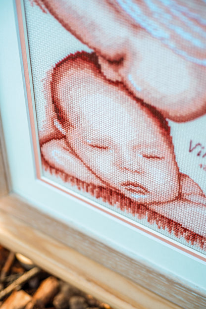 Cross stitch of two children with a heart
