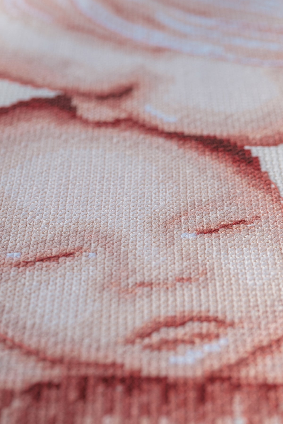 Cross stitch of two children with a heart