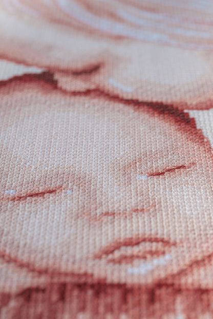 Cross stitch of two children with a heart