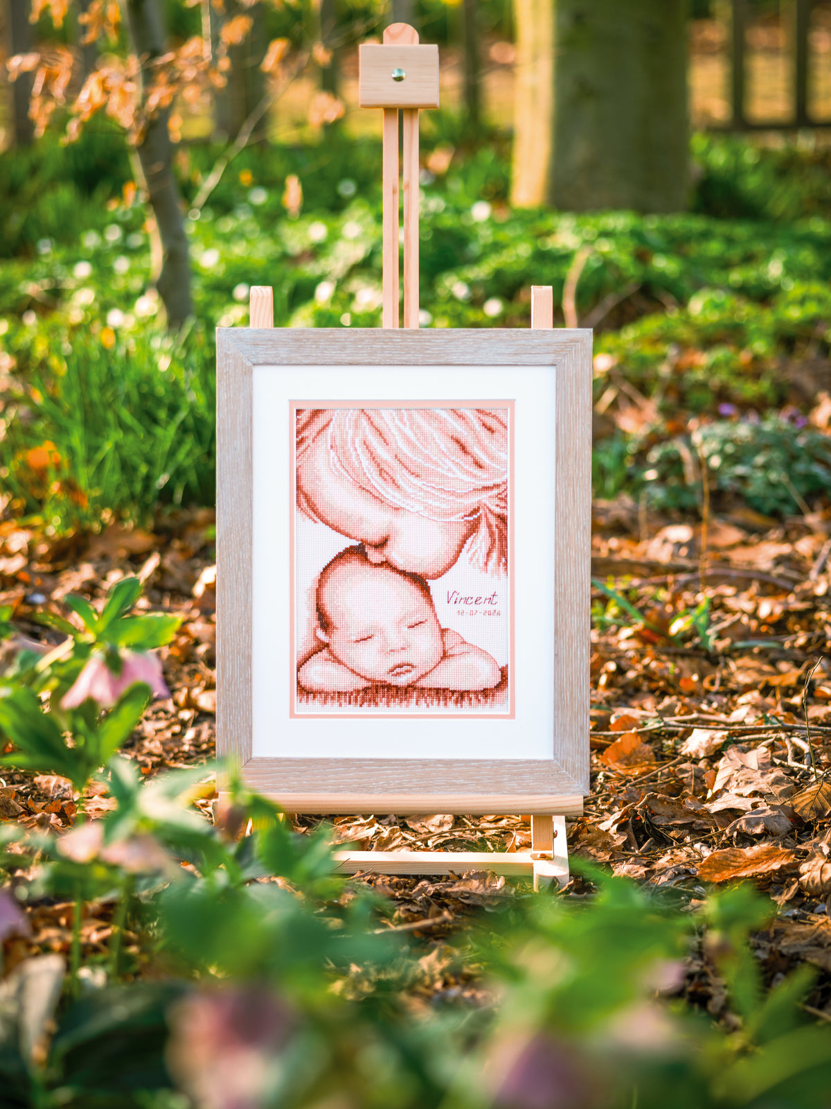 Cross stitch of two children with a heart