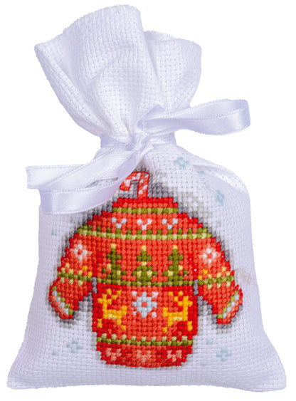 Three cross stitched Christmas gift bags tied with ribbon