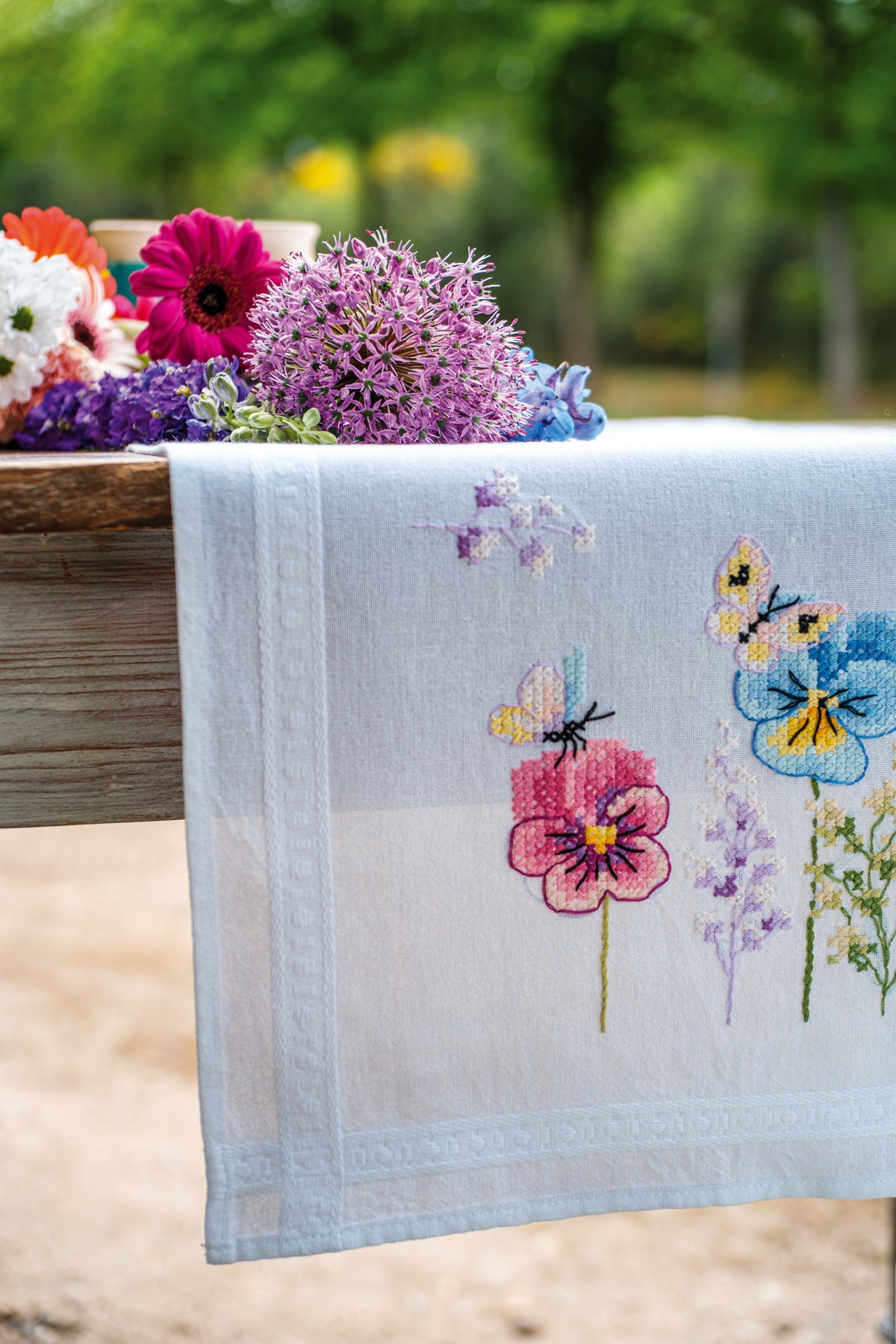Vervaco Violets embroidered table runner kit showing the finished piece