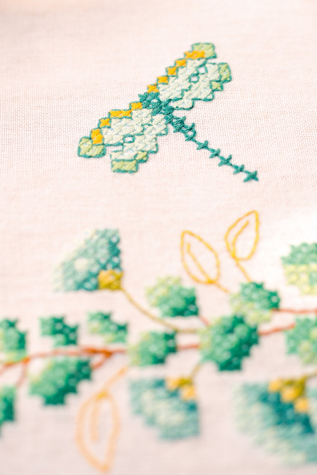 Square white tablecloth embroidered with green eucalyptus sprigs