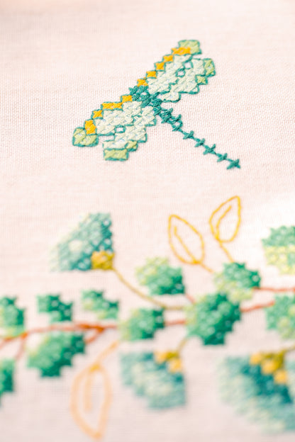 Square white tablecloth embroidered with green eucalyptus sprigs