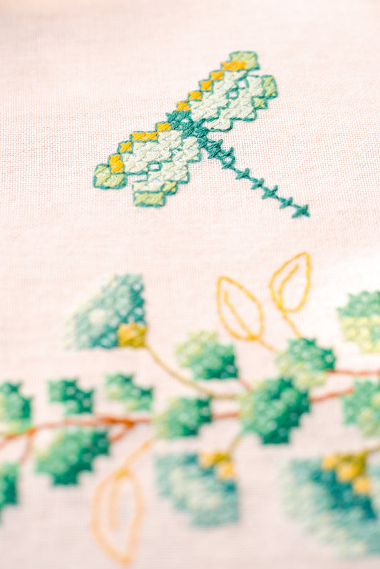 Square white tablecloth embroidered with green eucalyptus sprigs
