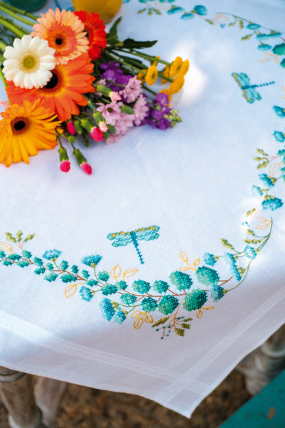 Square white tablecloth embroidered with green eucalyptus sprigs