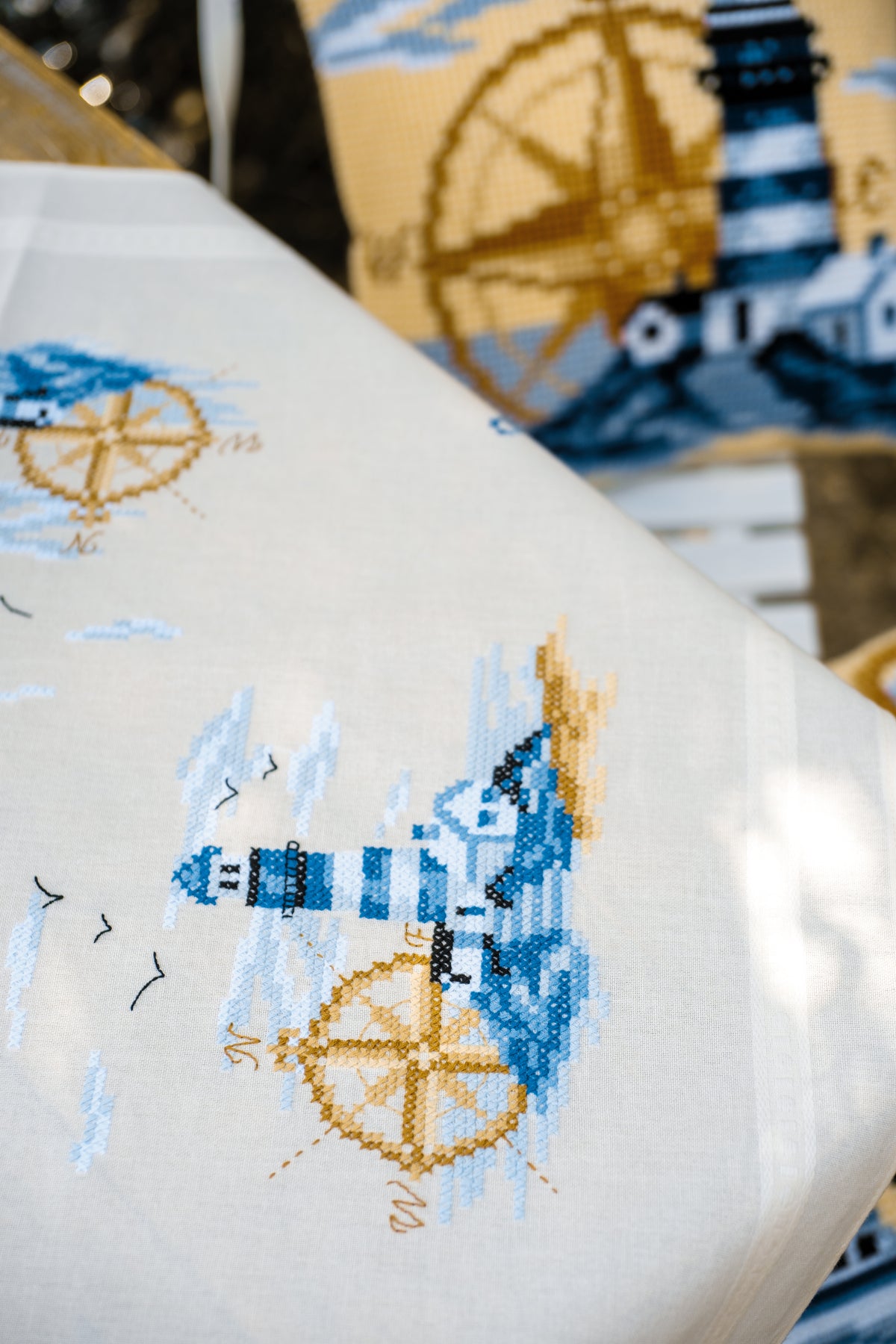 Square ecru tablecloth with navy embroidered pattern