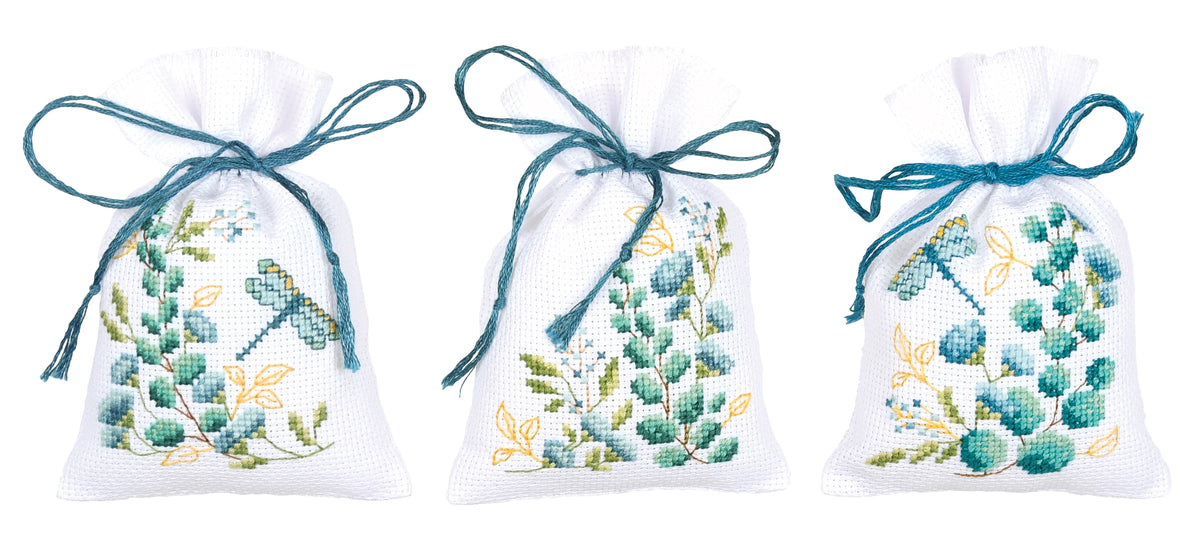 Three small white gift bags cross stitched with nature motifs