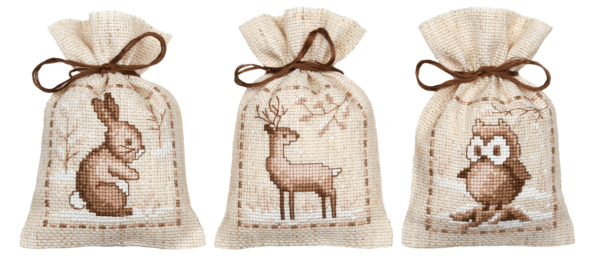 Three natural linen gift bags cross stitched with winter animals