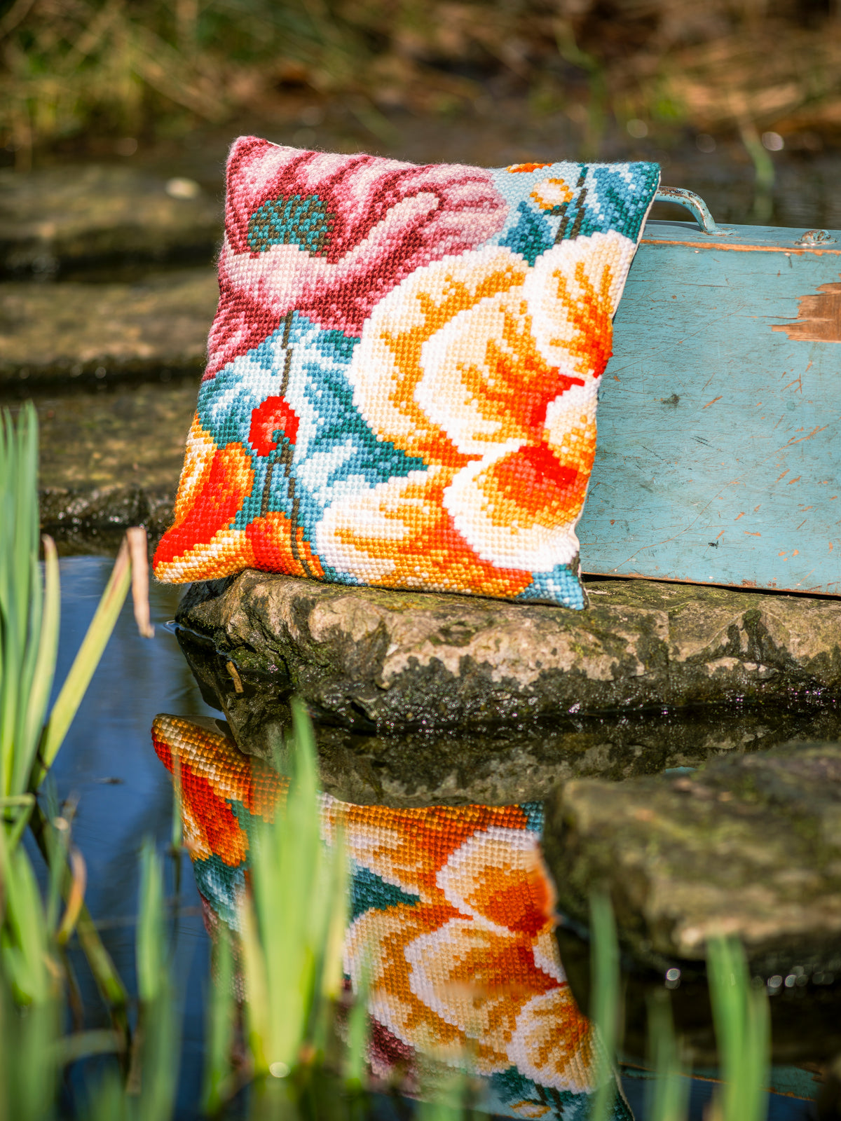 Square cushion stitched with bright red poppies