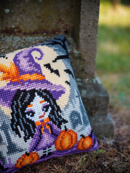 Square cushion cross stitched with a girl in a Halloween costume