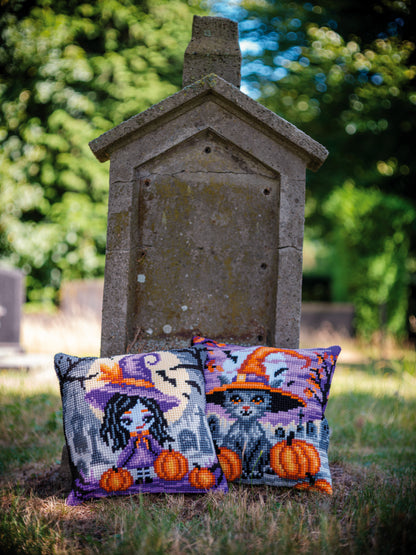 Square cushion cross stitched with a girl in a Halloween costume
