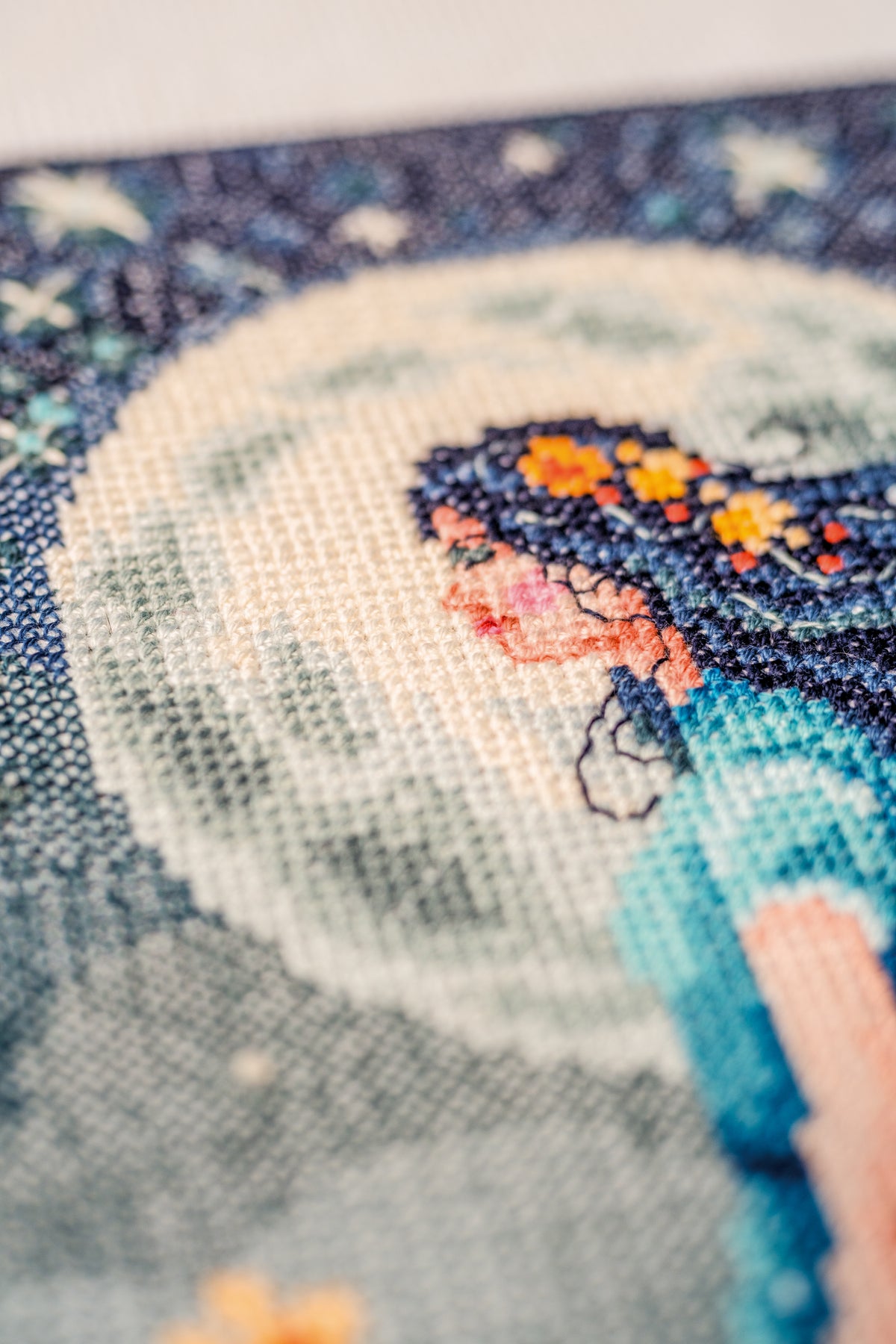 Cross stitch picture of a girl with the moon