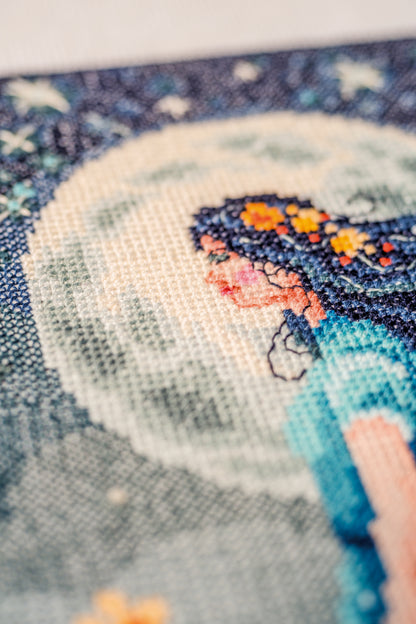 Cross stitch picture of a girl with the moon