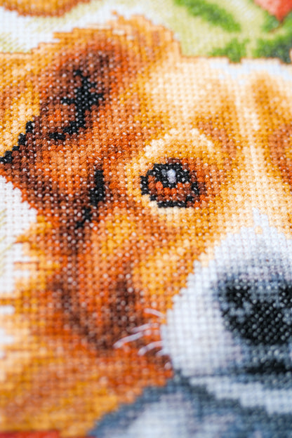 Cross stitch picture of a dog among autumn leaves