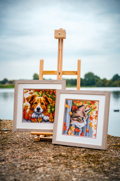 Cross stitch picture of a dog among autumn leaves