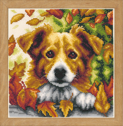 Cross stitch picture of a dog among autumn leaves
