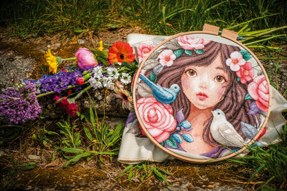 Cross stitch picture of a woman surrounded by roses