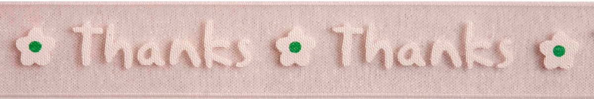 Reel of mint & white on baby pink ribbon printed with the word Thanks