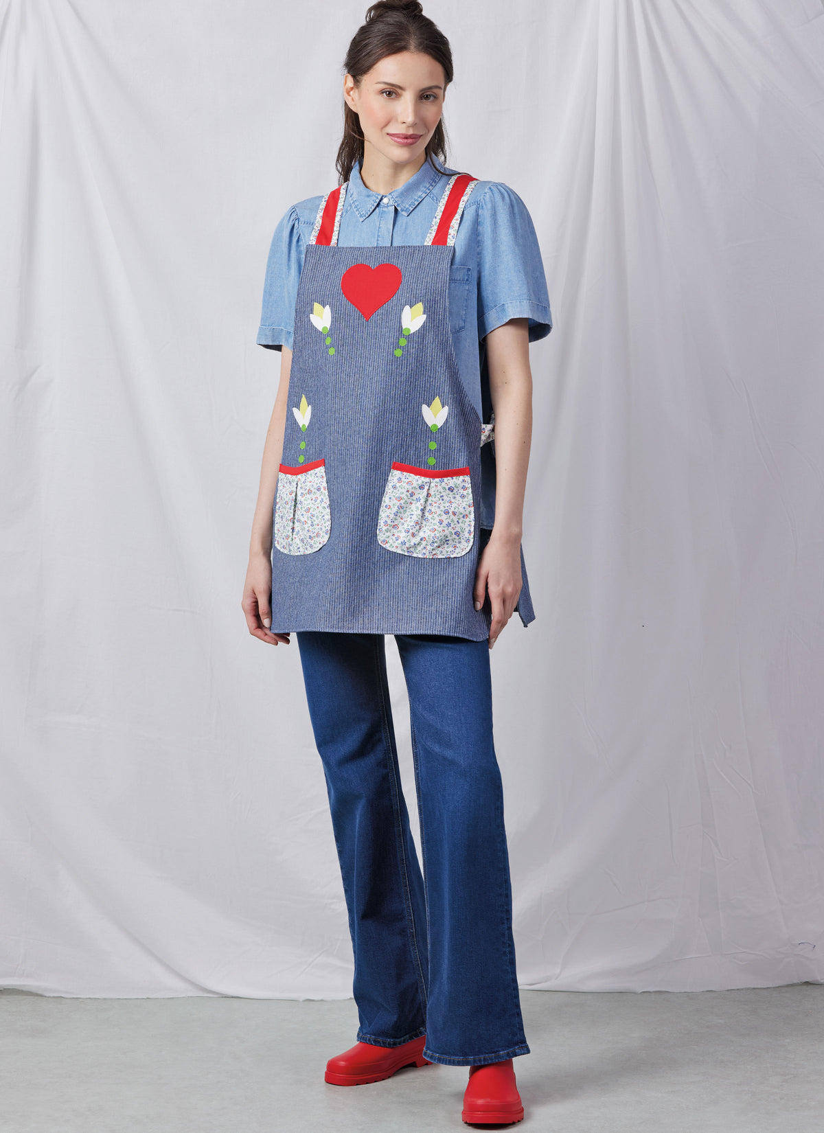 Simplicity S3119 pattern envelope showing aprons with contrast straps and floral appliques