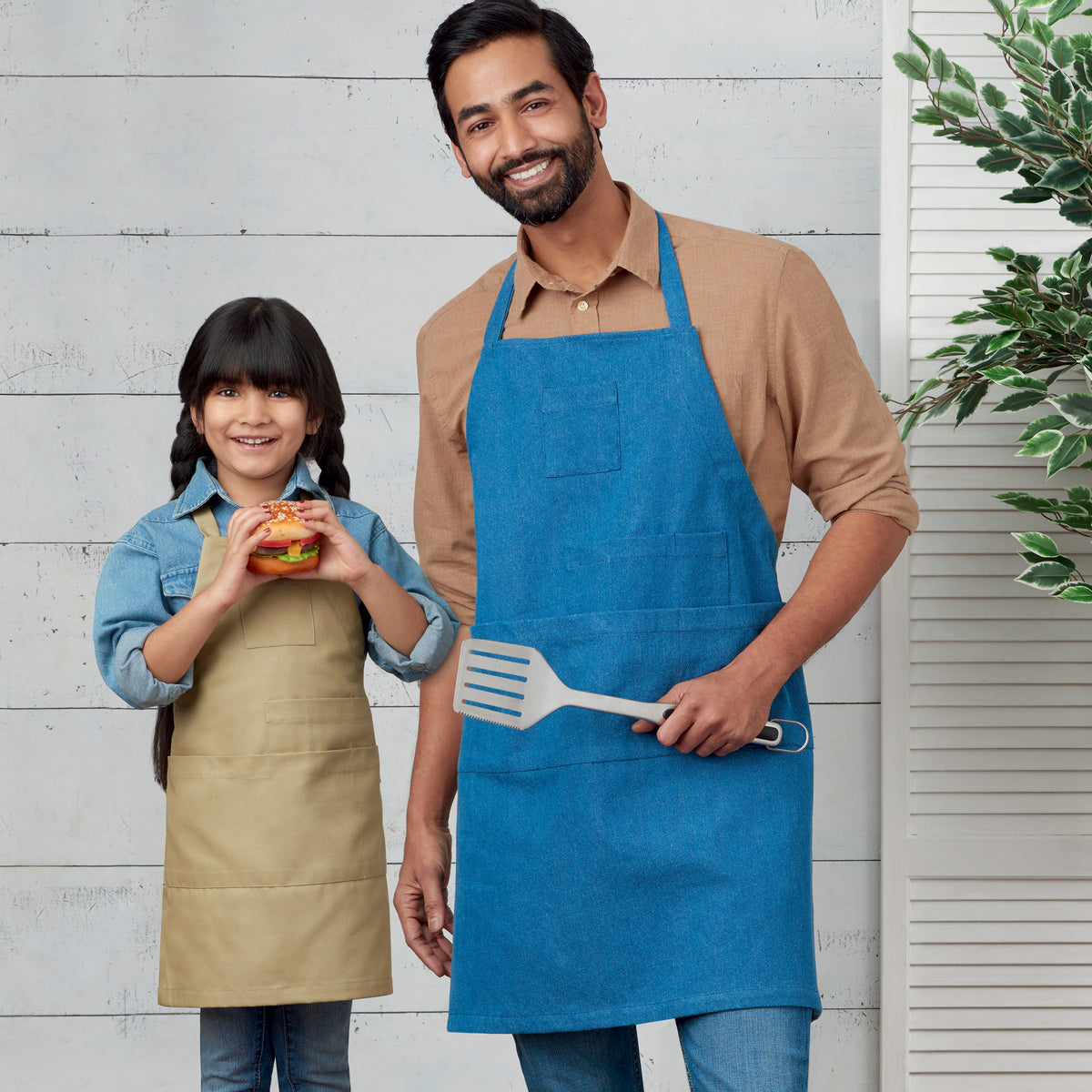 Simplicity S9301 sewing pattern envelope showing family aprons designs