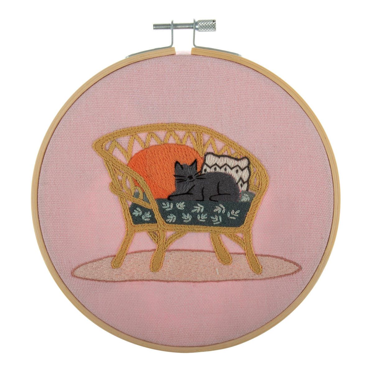 Embroidery hoop kit showing a stitched cat on wicker chair design