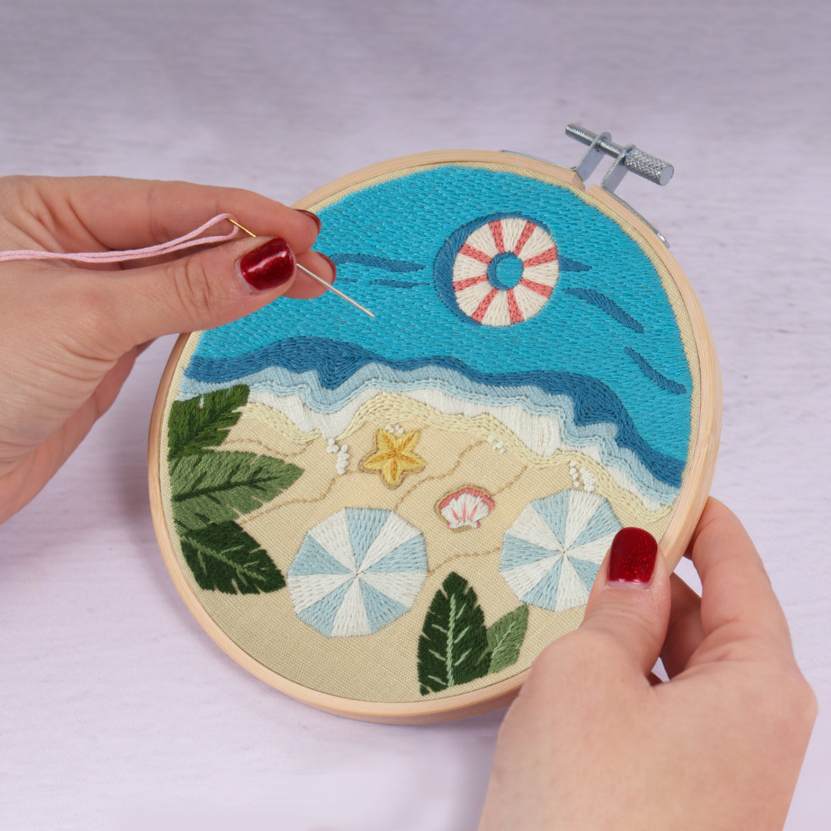 Embroidery hoop kit showing a stitched beach design