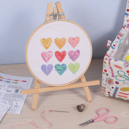 Embroidery hoop kit showing a stitched ombre hearts design