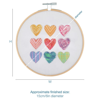 Embroidery hoop kit showing a stitched ombre hearts design