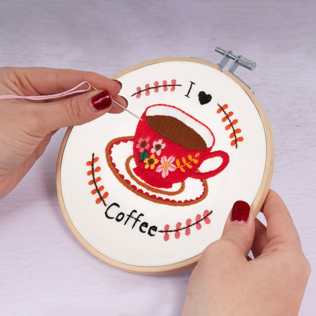 Embroidery hoop kit showing a stitched i love coffee design
