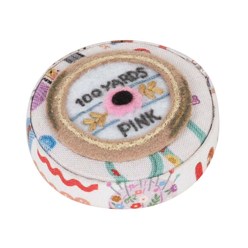 Round fabric-covered retractable tape measure with haberdashery notions print