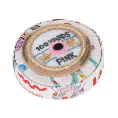 Round fabric-covered retractable tape measure with haberdashery notions print