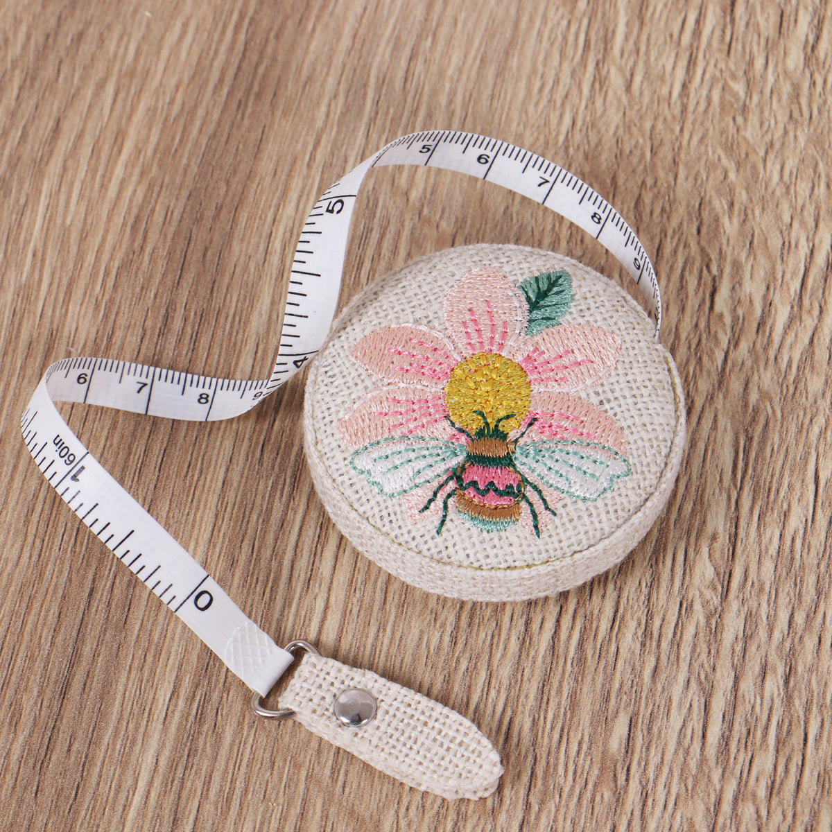 Retractable tape measure with embroidered patchwork bee