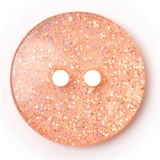 Peach round button with silver glitter set into a clear finish