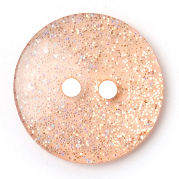 Pale pink round button with silver glitter set into a clear finish