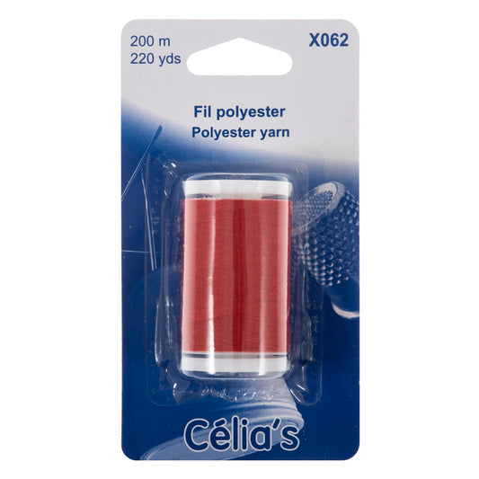 Reel of red polyester thread on blue card